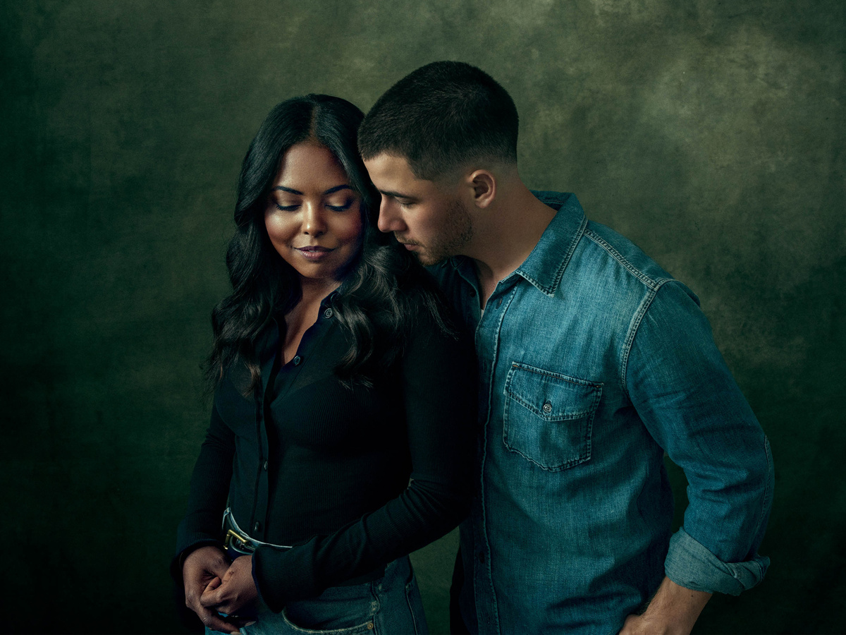 Adrienne Warren and Nick Jonas pose together, with Adrienne looking down and Nick close to her shoulder